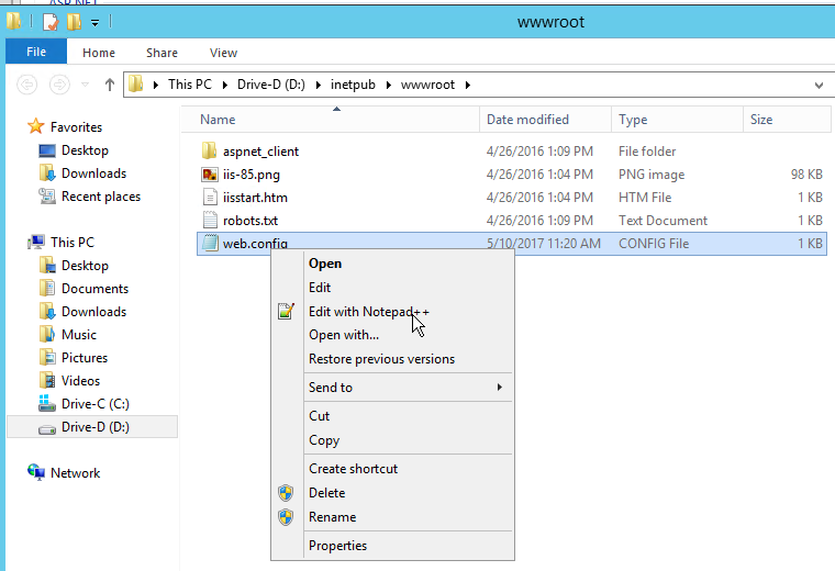 Windows Explorer showing the site's wwwroot folder with web.config right-clicked, ready to open in a text editor.